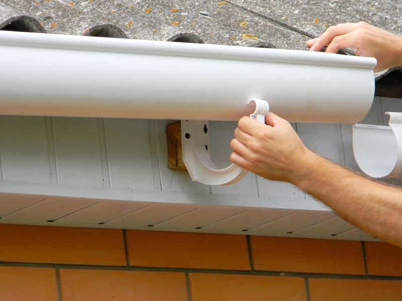 man placing gutter on home