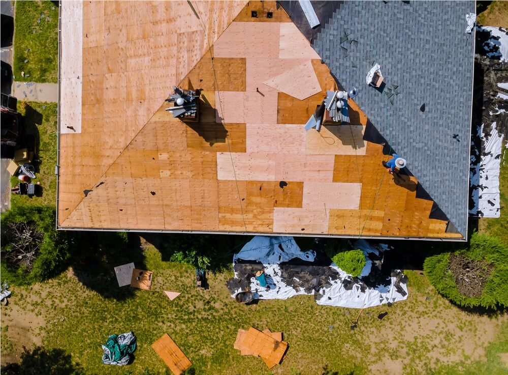 men on roof attaching new shingles